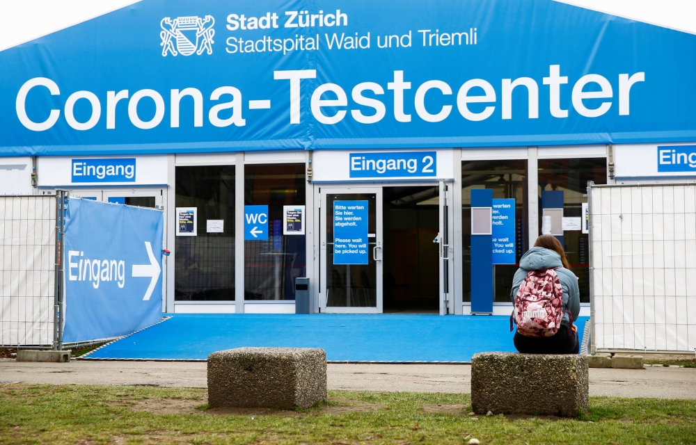 A woman sits in front of a COVID-19 testing site of the Stadtspital Waid and Triemli hospital, as the spread of the coronavirus disease (COVID-19) continues, in Zurich, Switzerland March 3, 2021. REUTERS/Arnd Wiegmann