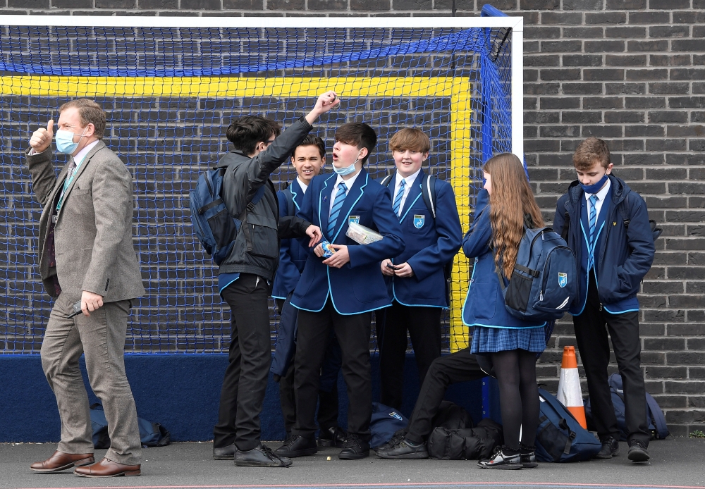 Year 9 students react as they speak with Principal, James Fisher, on the first day back at school, as the coronavirus disease (COVID-19) lockdown begins to ease at Harris Academy Sutton, south London, Britain, March 8, 2021. REUTERS/Toby Melville