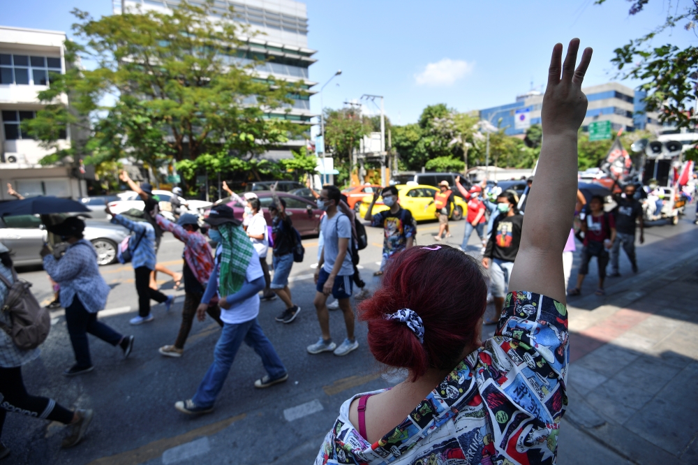 Anti-government demonstrators flash the three-finger salute during a march from Kasetsart University towards Democracy monument, in Bangkok, Thailand, March 7, 2021. REUTERS/Chalinee Thirasupa