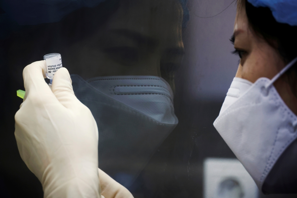 Registered nurse Kim Eun-suk measures a dose of the Pfizer-BioNTech coronavirus disease (COVID-19) vaccine at a COVID-19 vaccination center in Seoul, South Korea, March 10, 2021. REUTERS/Kim Hong-Ji