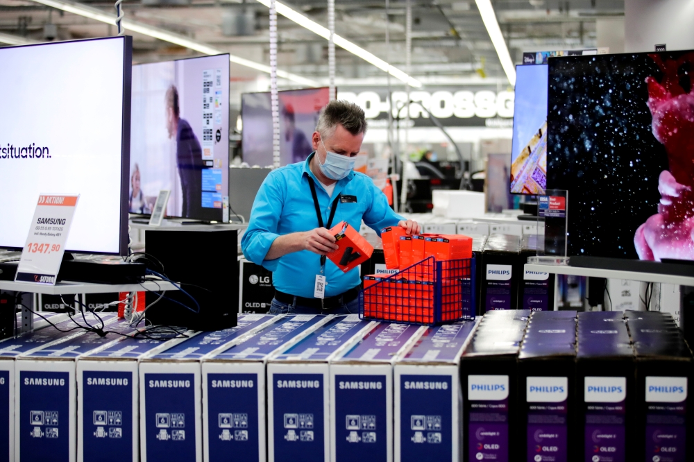 File photo: An employee wearing a protective mask works at a Saturn electronic store as the coronavirus disease (COVID-19) lockdown measures are eased in Berlin, Germany, March 11, 2021. Reuters/Hannibal Hanschke/File Photo