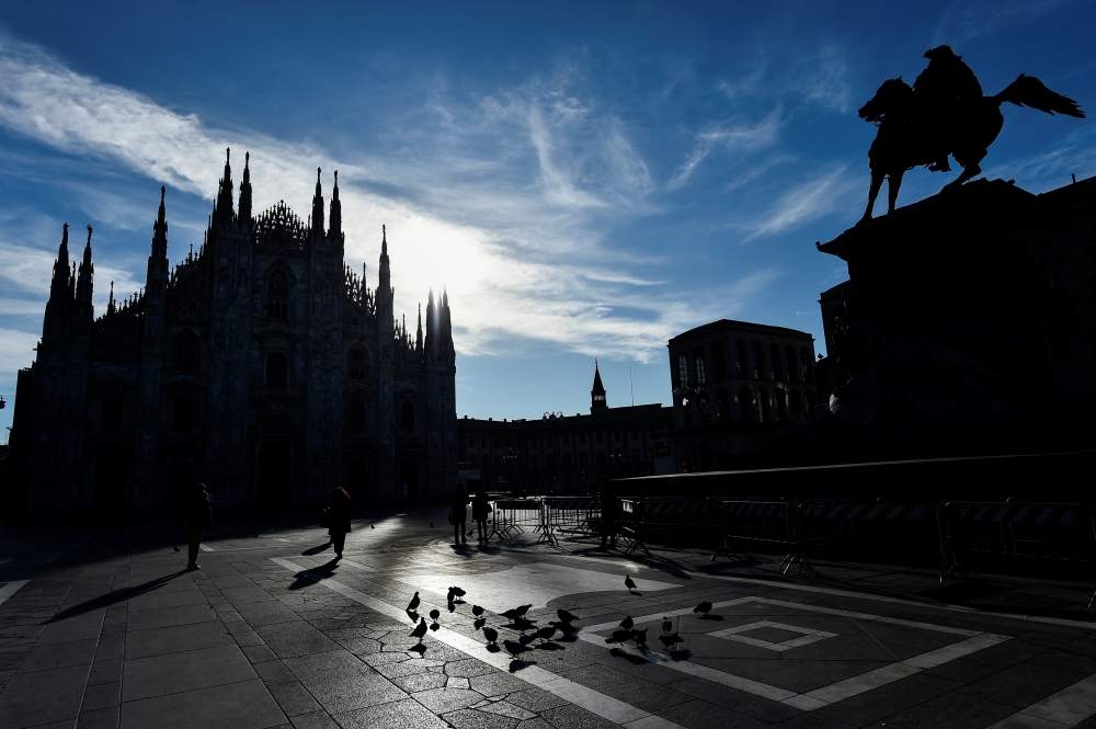 People walk in Duomo square as the region of Lombardy becomes a 'red zone', going into lockdown as the country struggles to reduce the coronavirus disease (COVID-19) infections, in Milan, Italy, March 15, 2021. REUTERS/Flavio Lo Scalzo