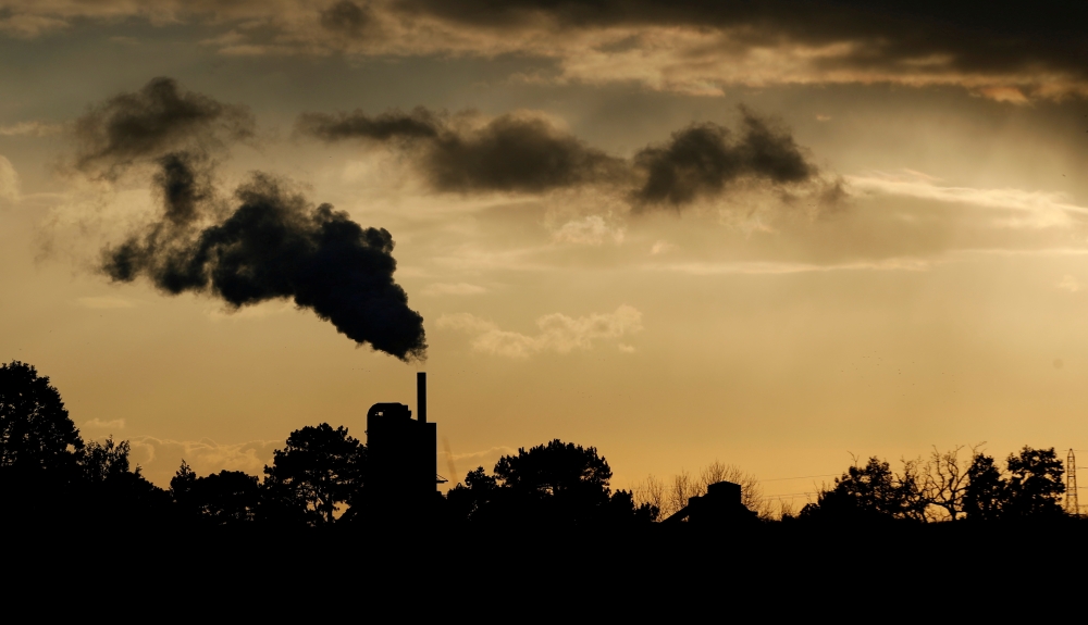 Smoke rises above a factory at sunset in Rugby, Britain February 10, 2021. REUTERS/Matthew Childs/File Photo