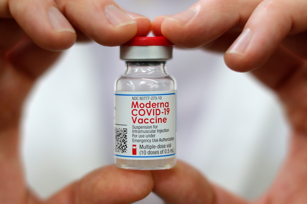 Walmart pharmacist holds a vial of the Moderna coronavirus disease (COVID-19) vaccine inside a Walmart department store as Walmart and other major U.S. pharmacies take part in the Federal Retail Pharmacy Program, to increase vaccinations in the U.S. in We