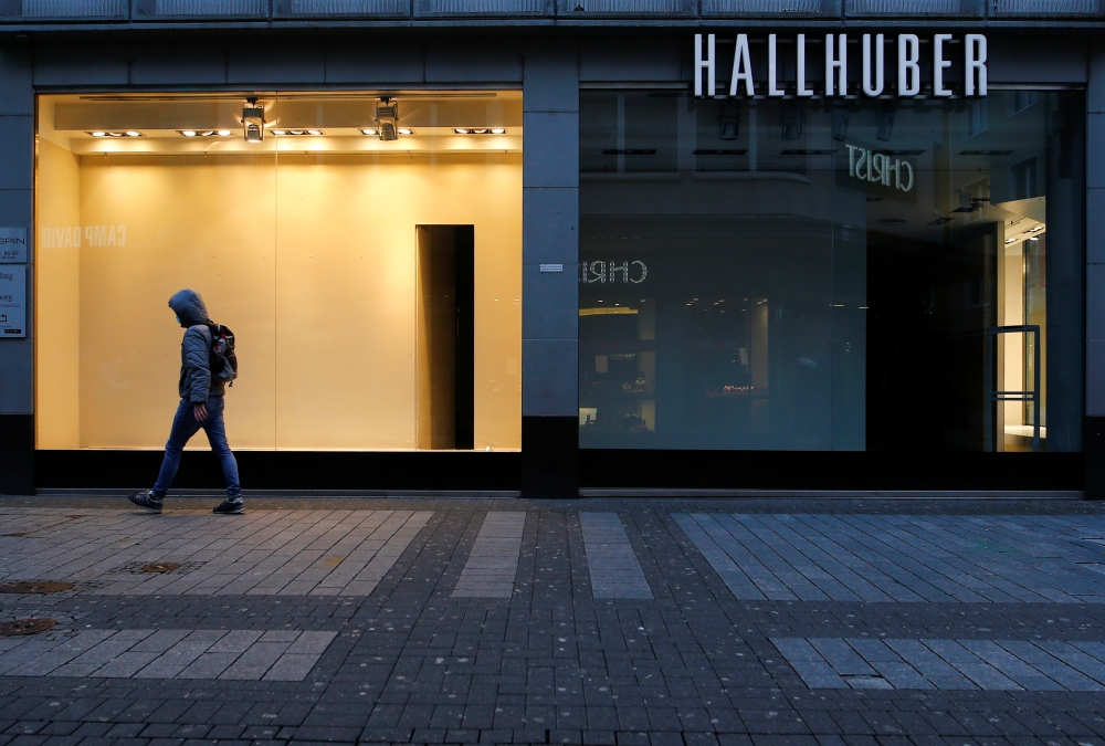 A man walks along a closed shop at the main shopping street Hohe Strasse amid the coronavirus disease (COVID-19) pandemic in Cologne, Germany, March 18, 2021. Picture taken March 18, 2021. REUTERS/Thilo Schmuelgen