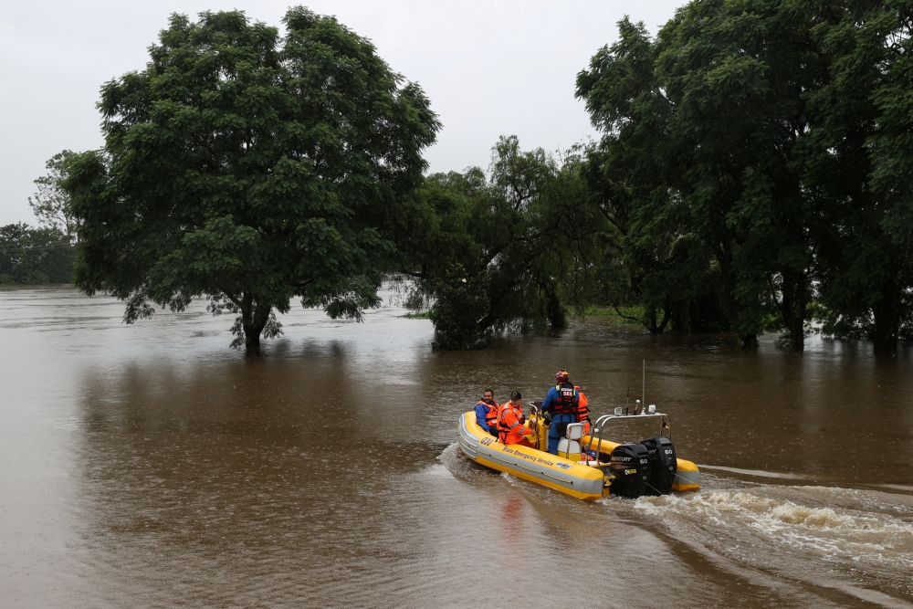State Emergency Service personnel transport a dentist by boat from the suburb of Windsor to North Richmond across floodwaters, so he can attend to patients unreachable by car, as the state of New South Wales experiences widespread flooding and severe weat