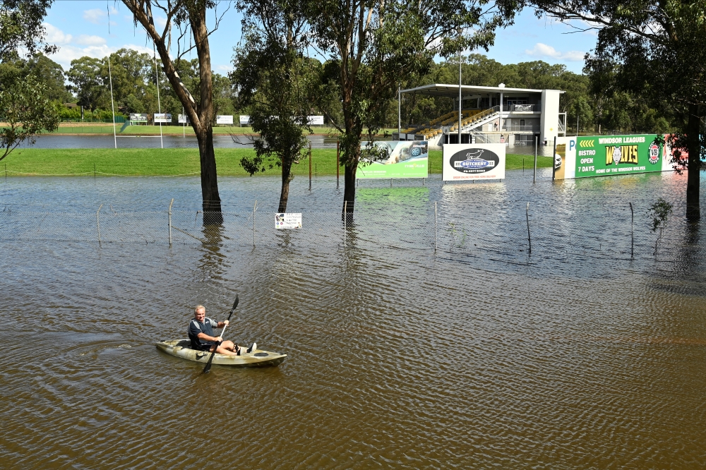 A local resident kayaks through floodwaters in front of the Windsor Leagues Club in the suburb of South Windsor as the state of New South Wales experiences widespread flooding and severe weather, near Sydney, Australia, March 24, 2021. REUTERS/Jaimi Joy