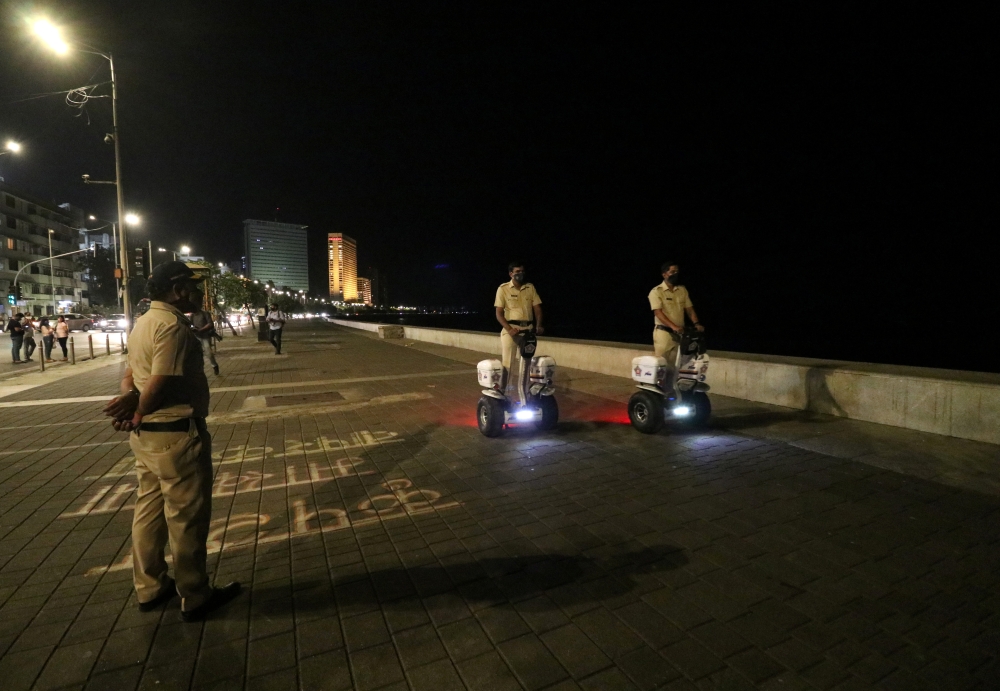 Police officers patrol on Segways along the promenade at Marine Drive during a curfew to limit the spread of the coronavirus disease (COVID-19), in Mumbai, India, March 29, 2021. REUTERS/Niharika Kulkarni
