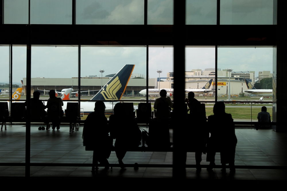 People look at a Singapore Airlines plane, amid the spread of the coronavirus disease (COVID-19), at a viewing gallery of the Changi Airport in Singapore October 12, 2020. Reuters/Edgar Su/File Photo