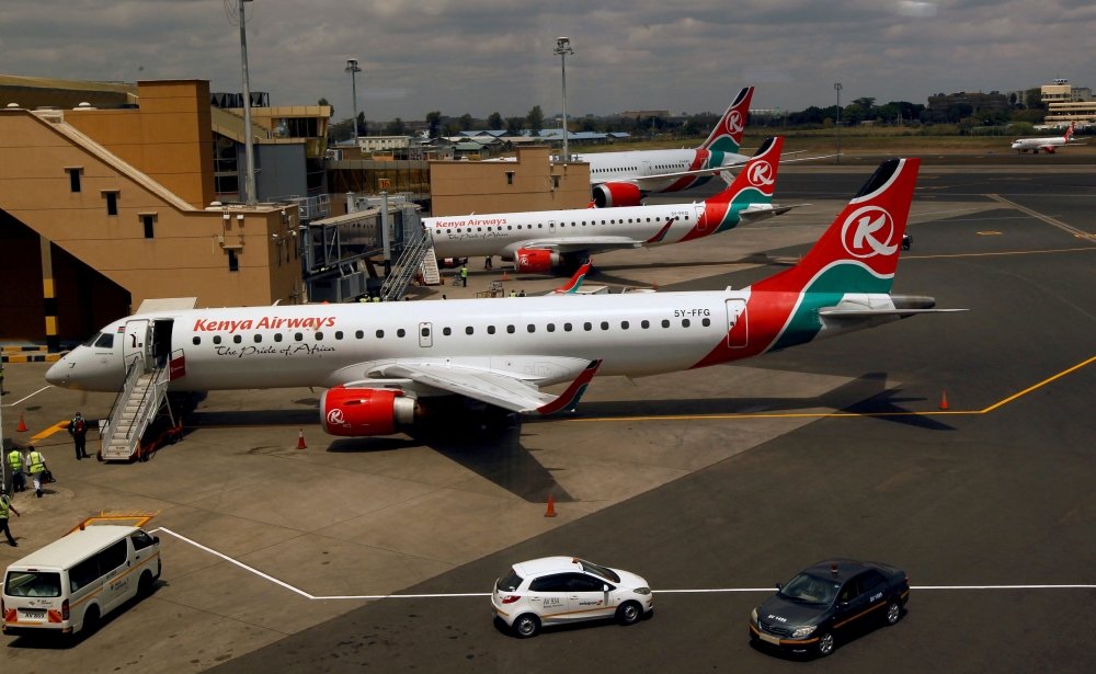 FILE PHOTO: Kenya Airways planes are seen through a window as the Jomo Kenyatta international airport reopens after flights were suspended following the coronavirus disease (COVID-19) outbreak in Nairobi, Kenya August 1, 2020. REUTERS/Njeri Mwangi/File Ph
