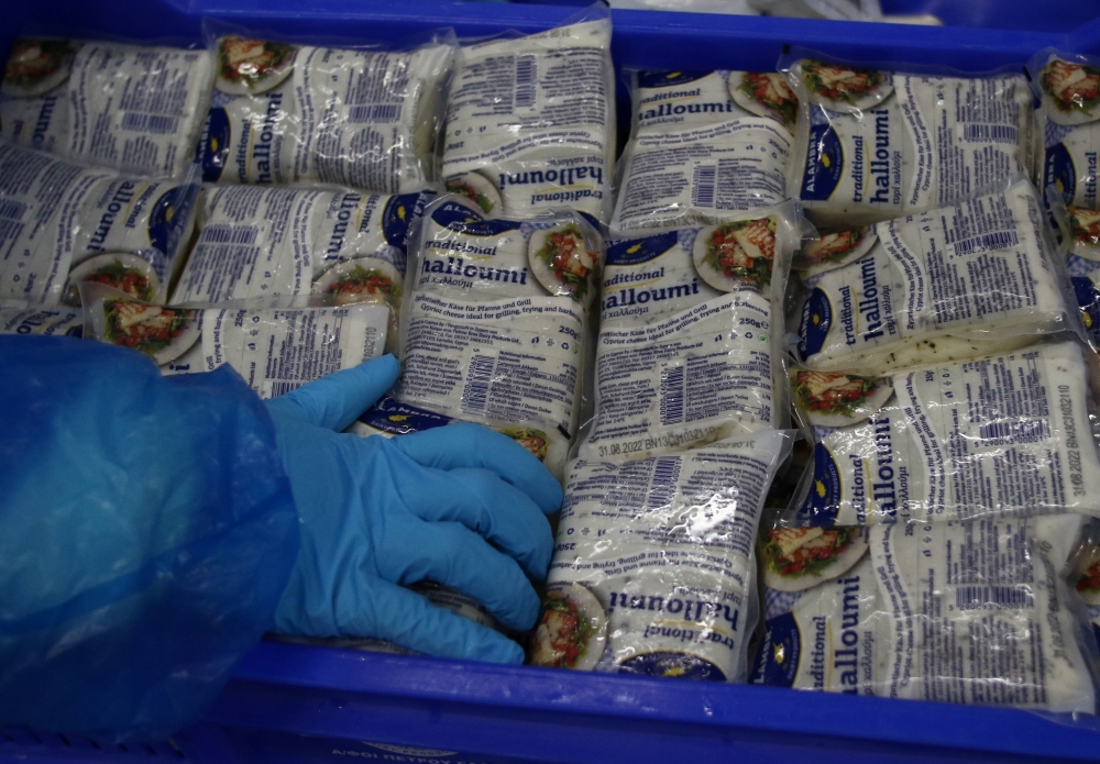 Workers pack halloumi cheese at the Petrou Bros Dairy in Aradippou, Cyprus, April 2, 2021. Picture taken April 2, 2021. REUTERS/Yiannis Kourtoglou