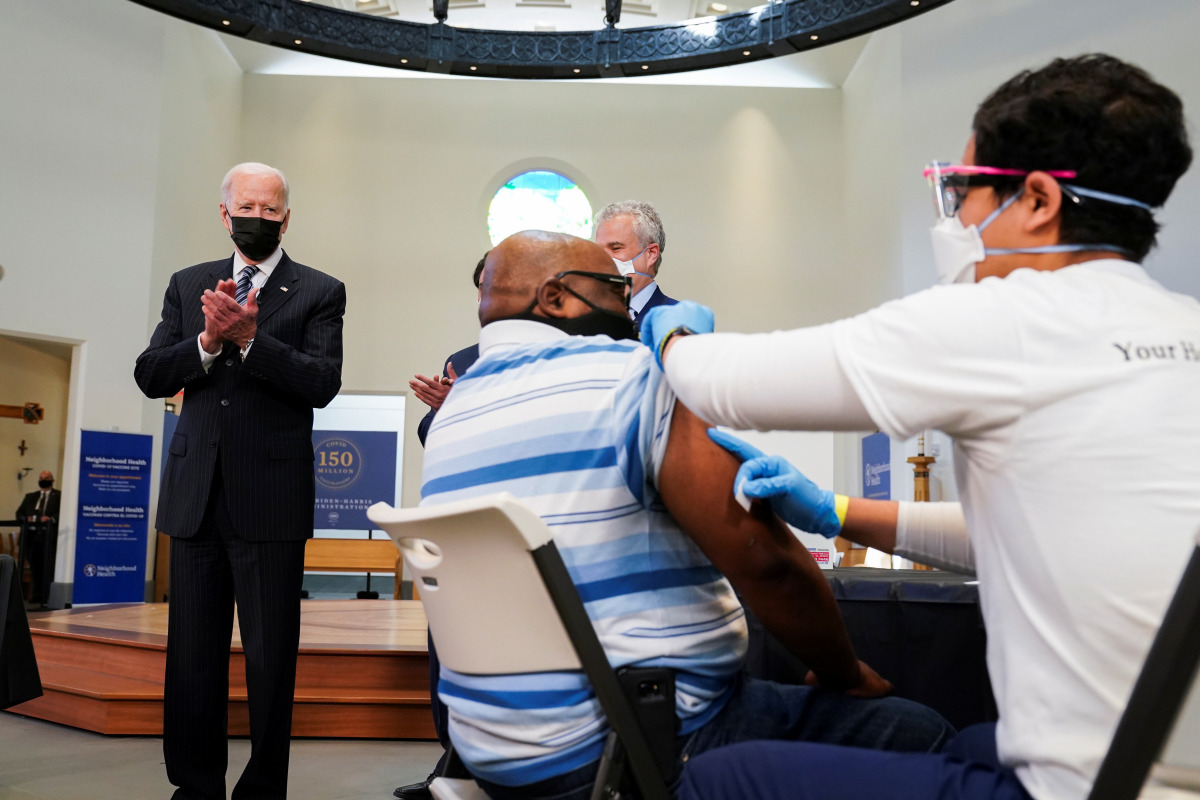 U.S. President Joe Biden applauds a man as he receives a vaccine at the coronavirus disease (COVID-19) vaccination site at Virginia Theological Seminary in Alexandria, Virginia, U.S., April 6, 2021. REUTERS/Kevin Lamarque
