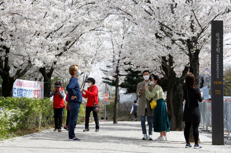 People walk near a cherry blossom street, closed to avoid the spread of the coronavirus disease (COVID-19), in Seoul, South Korea, April 1, 2021. REUTERS/Heo Ran
