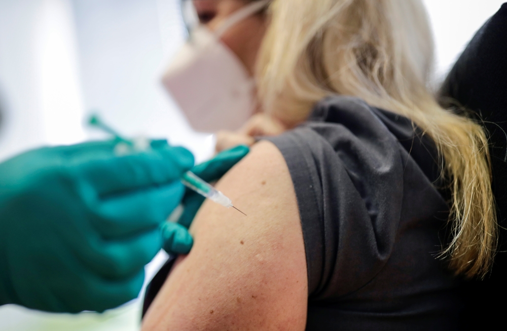 A woman receives a dose of the Pfizer-BioNTech coronavirus disease (COVID-19) vaccine in a doctors' practice in Berlin, Germany, April 7, 2021. Reuters/Hannibal Hanschke