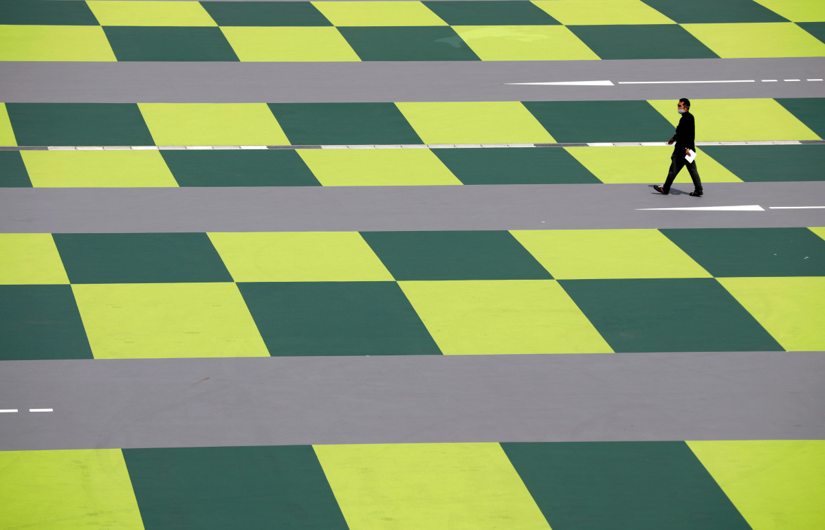 A man wearing a protective face mask amid the coronavirus disease (COVID-19) pandemic walks on a parking lot at a shopping mall in Tokyo, Japan, April 8, 2021. REUTERS/Kim Kyung-Hoon TPX IMAGES OF THE DAY
