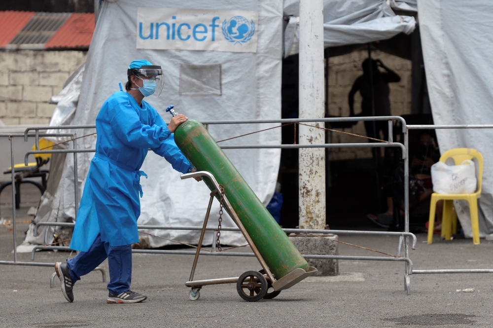 A health worker transports an oxygen tank at a coronavirus disease (COVID-19) facility at Santa Ana Hospital, in Manila, Philippines, April 9, 2021. REUTERS/Lisa Marie David