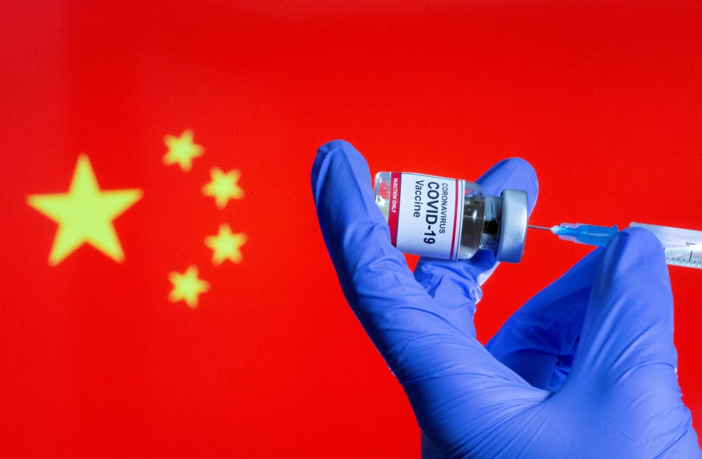 FILE PHOTO: A woman holds a small bottle labeled with a 