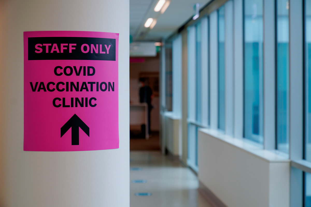 FILE PHOTO: FILE PHOTO; A sign for a COVID-19 vaccination clinic is seen as high-risk workers receive the first vaccines in the state of Victoria's rollout of the program, in Melbourne, Australia, February 22, 2021. REUTERS/Sandra Sanders/File Photo
