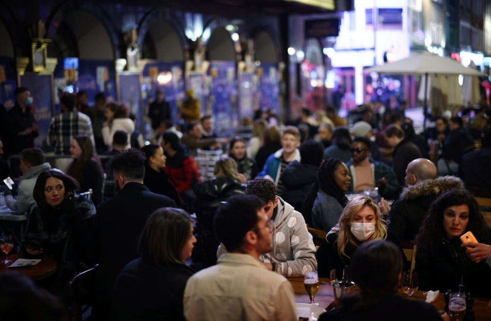 People enjoy the evening at an outside restaurant area in Soho, as the coronavirus disease (COVID-19) restrictions ease, in London, Britain April 12, 2021. REUTERS/Henry Nicholls
