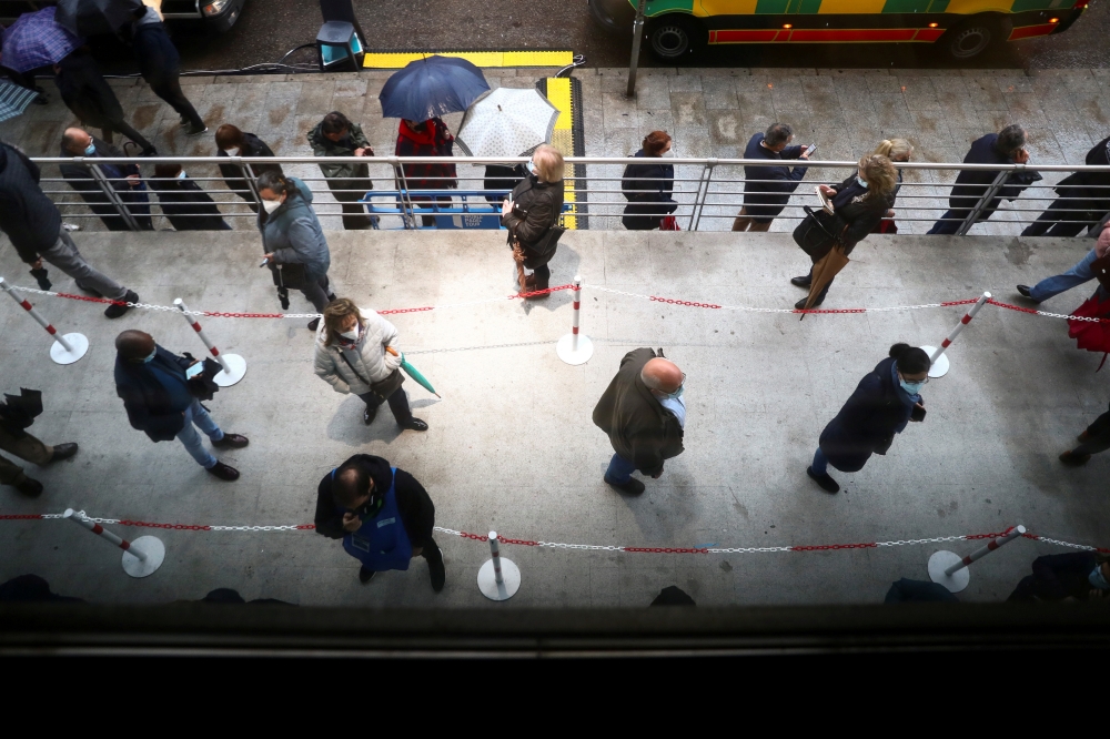 People queue to receive the AstraZeneca coronavirus disease (COVID-19) vaccine at a new mass vaccination centre in WiZink sports arena in Madrid, Spain, April 9, 2021. REUTERS/Sergio Perez/File Photo