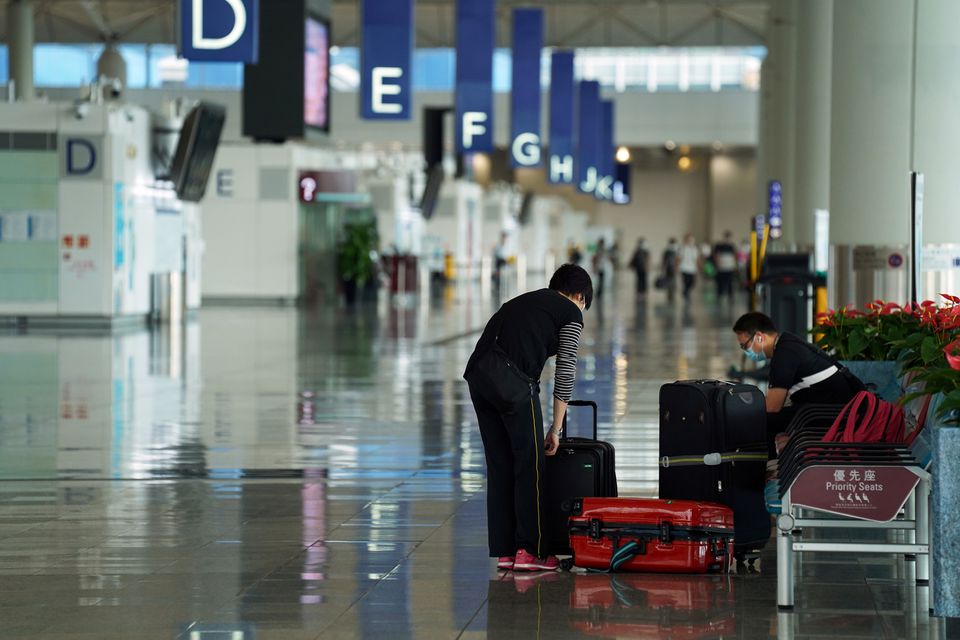 A woman, wearing a face mask following the coronavirus disease (COVID-19) outbreak, sorts luggage at Hong Kong International Airport in Hong Kong, China October 20, 2020. REUTERS/Lam Yik/File Photo

