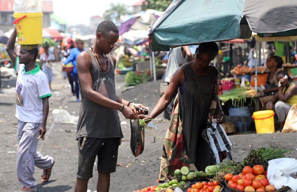 A Congolese man buys groceries at an open air market, amid concerns about the spread of coronavirus disease (COVID-19) in Kinshasa, Democratic Republic of Congo, March 28, 2020. REUTERS/Kenny Katombe/File Photo