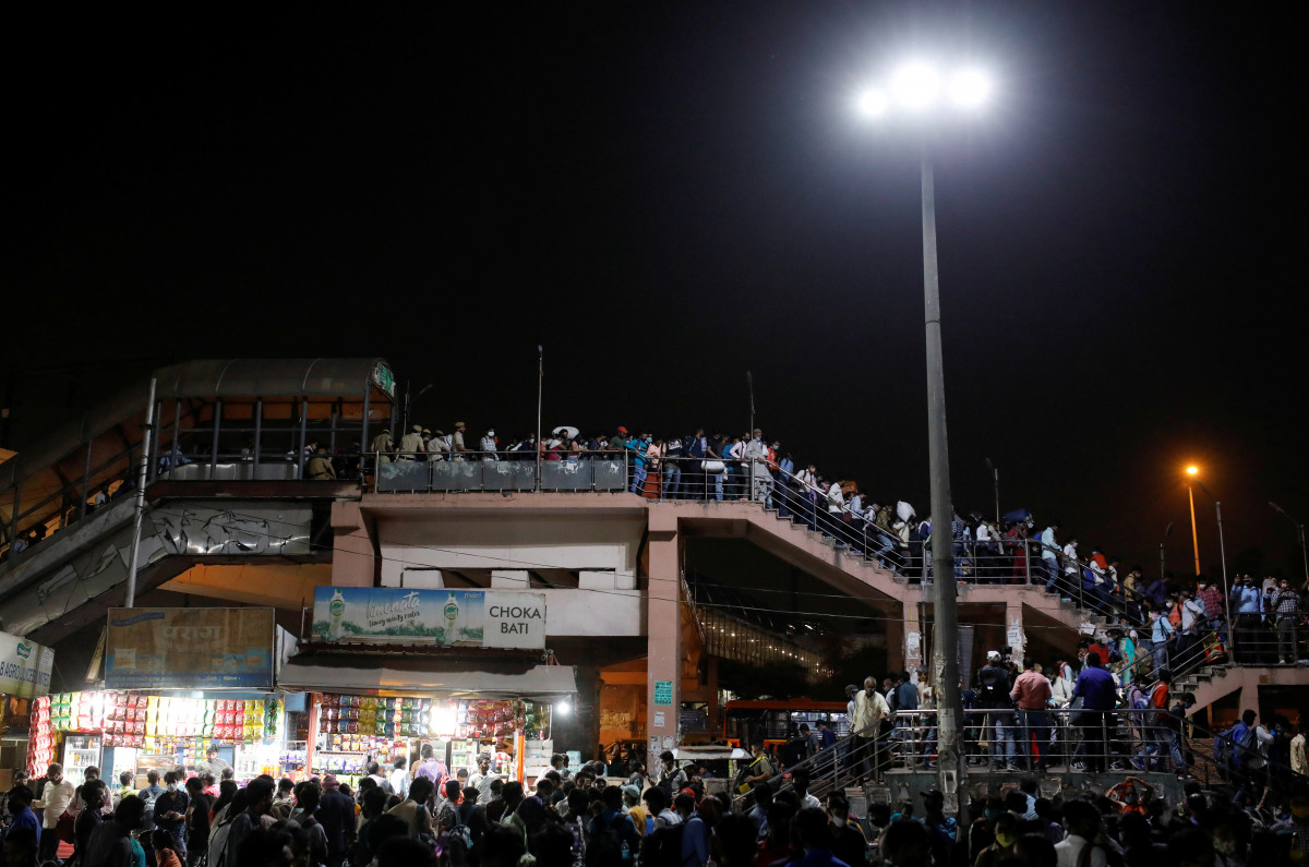 Migrant workers arrive at a bus station to board buses to return to their villages after Delhi government ordered a six-day lockdown to limit the spread of the coronavirus disease (COVID-19), in Ghaziabad on the outskirts of New Delhi, India, April 19, 20