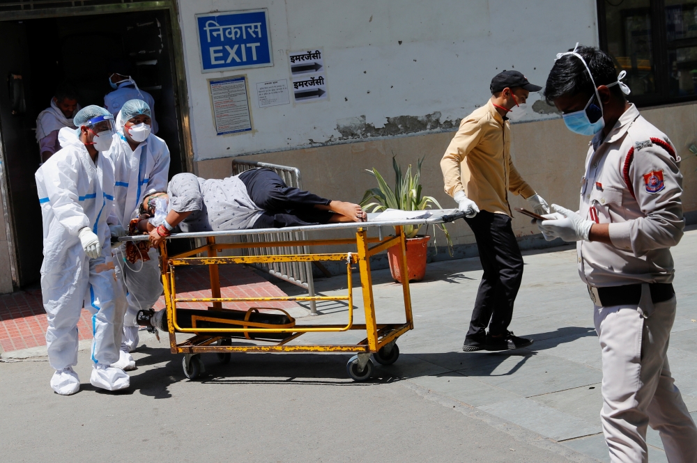 Health workers wearing personal protective equipment (PPE) carry a patient suffering from the coronavirus disease (COVID-19) outside the casualty ward at Guru Teg Bahadur hospital, in New Delhi, India, April 24, 2021. Reuters/Adnan Abidi