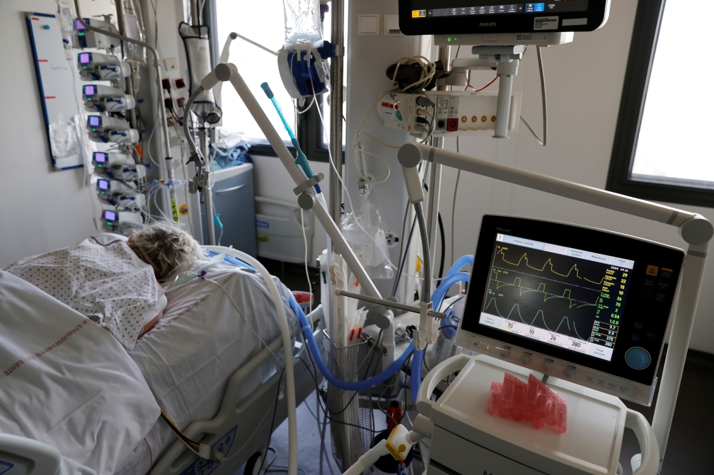 A patient suffering from the coronavirus disease (COVID-19) is treated in the Intensive Care Unit (ICU) at the hospital in Valenciennes, France, April 22, 2021. REUTERS/Pascal Rossignol