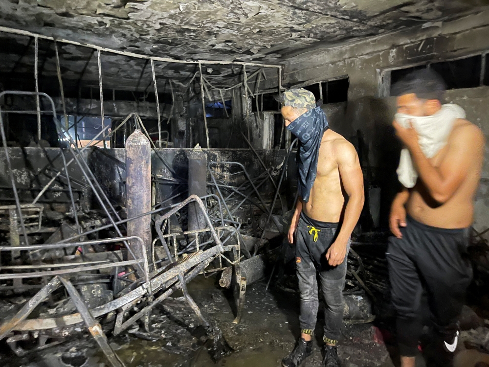 People look on at Ibn Khatib hospital after a fire caused by an oxygen tank explosion in Baghdad, Iraq, April 25, 2021. Reuters/Thaier Al-Sudani