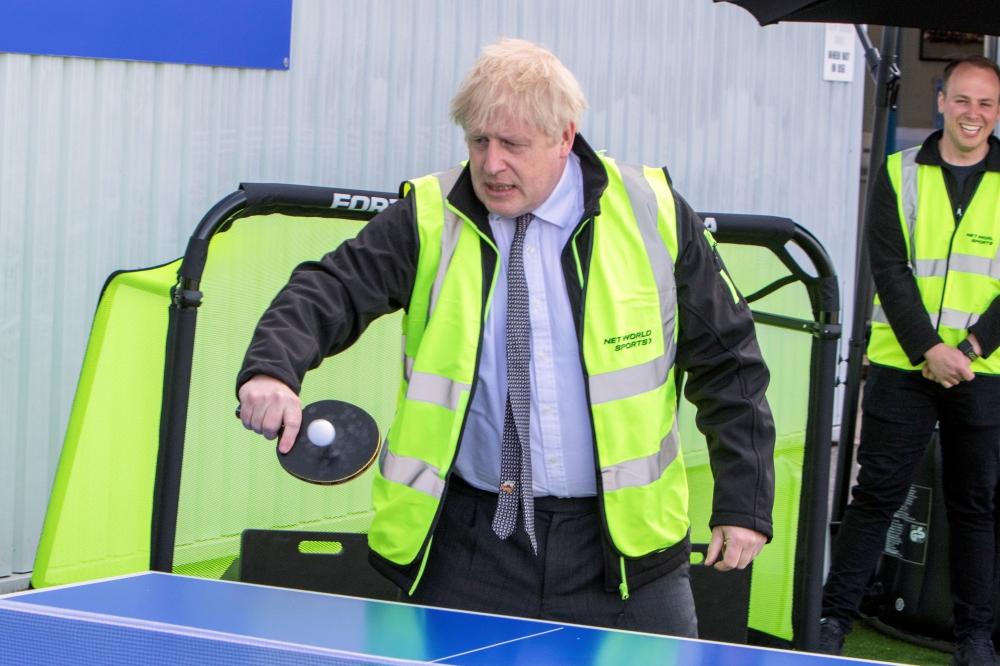 Britain's Prime Minister Boris Johnson plays table tennis during his visit at Net World Sports in Wrexham, Wales, Britain April 26, 2021. Rob Formstone/Pool via Reuters