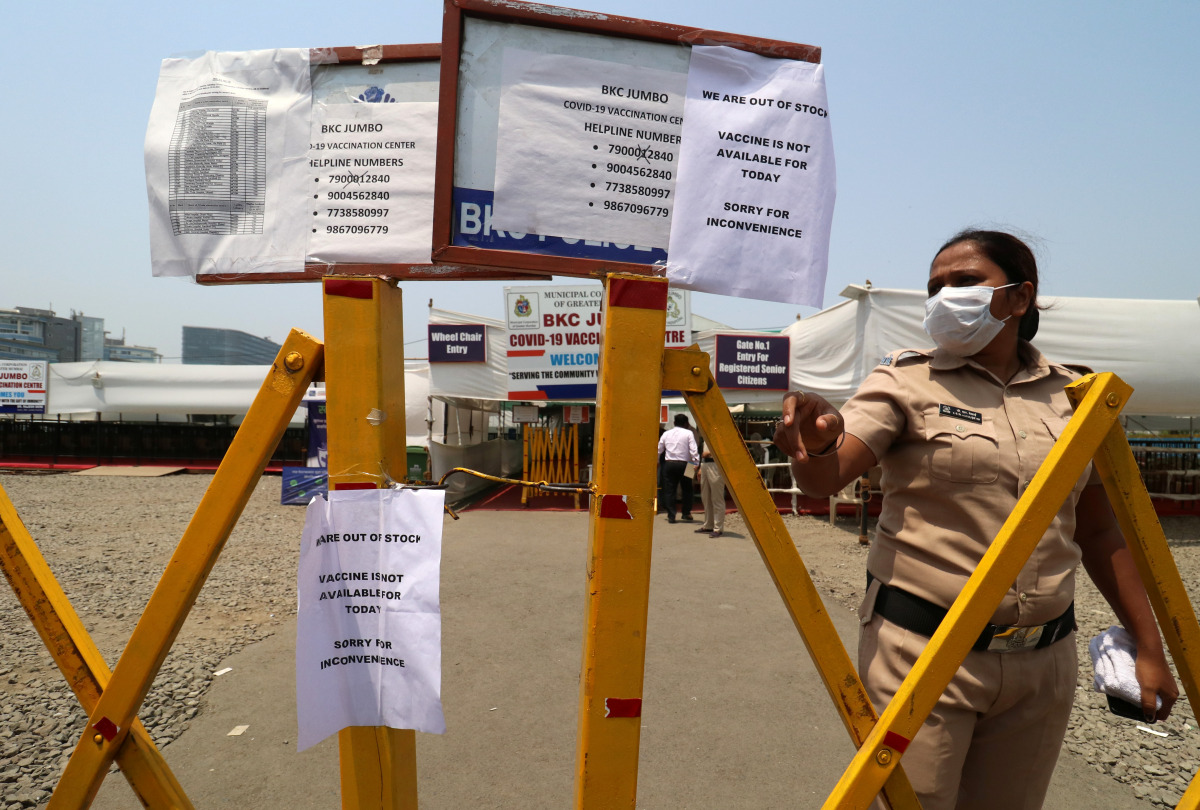 A policewoman gestures past notices about the shortage of vaccine for the coronavirus disease (COVID-19) at a vaccination centre in Mumbai, India, April 28, 2021. REUTERS/Niharika Kulkarni
