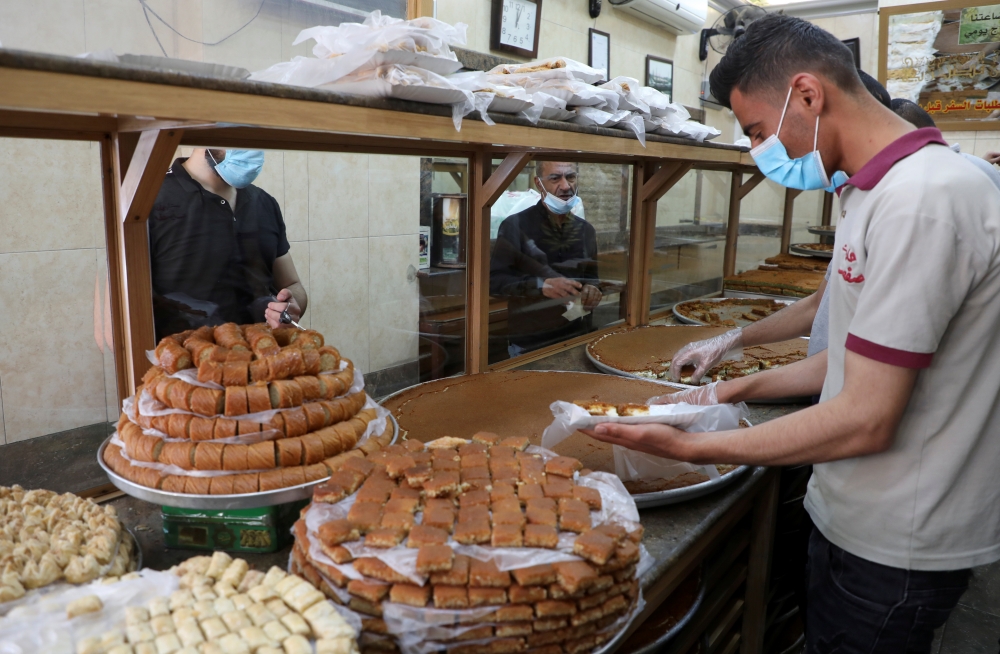 A worker sells sweets to customers during the holy fasting month of Ramadan in Beirut, Lebanon April 22, 2021. Picture taken April 22, 2021. REUTERS/Mohamed Azakir