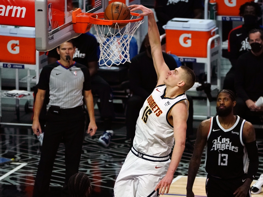 Denver Nuggets center Nikola Jokic (15) dunks for a basket in front of Los Angeles Clippers guard Paul George (13) during the second half at Staples Center. Gary A. Vasquez