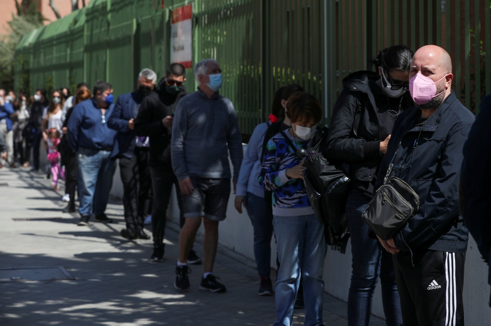 Voters, wearing protective face masks and keeping social distance, queue to access a polling station during Madrid's Regional elections, in Madrid, Spain, May 4, 2021. Reuters/Susana Vera