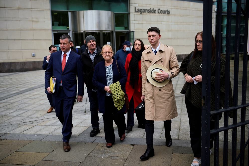Solicitor for the McCann family Niall Murphy (red tie) with Joe McCann's family, (left to right) son Fergal, widow Anne, daughter Nuala, nephew Fergal, and daughter Aine (right) depart Laganside Court, after the trial into the 1972 killing of official IRA