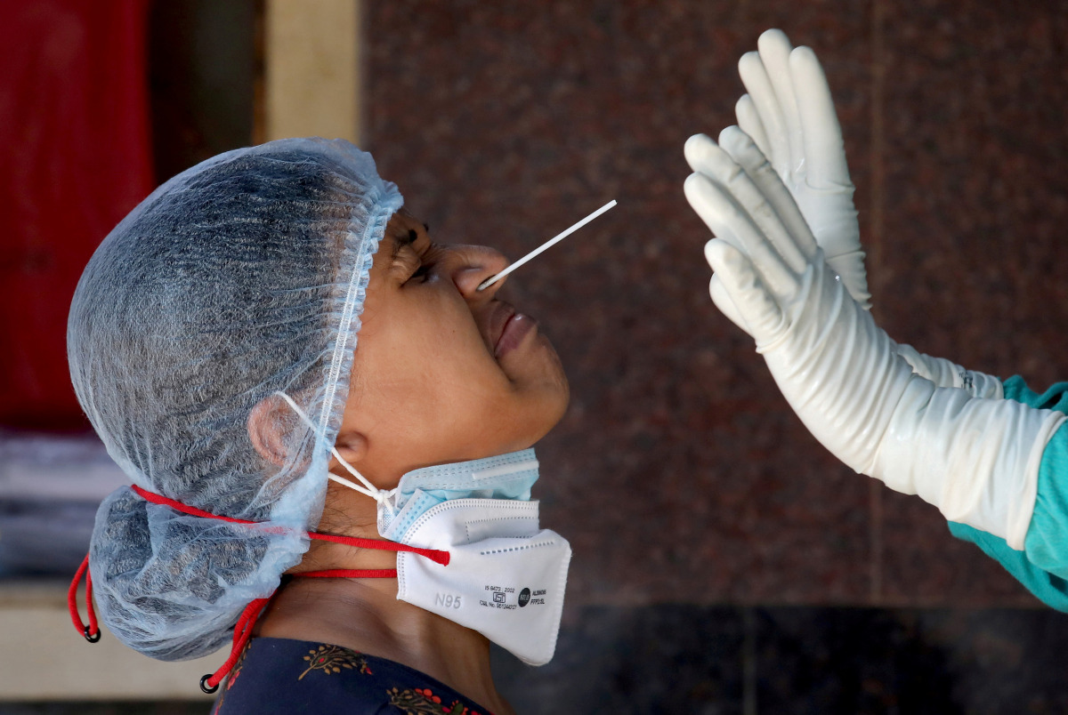 A woman reacts as a healthcare worker takes a nasal swab sample for a coronavirus disease (COVID-19) test at a government-run hospital, amidst the spread of the disease in Kolkata, India, May 6, 2021. REUTERS/Rupak De Chowdhuri TPX IMAGES OF THE DAY
