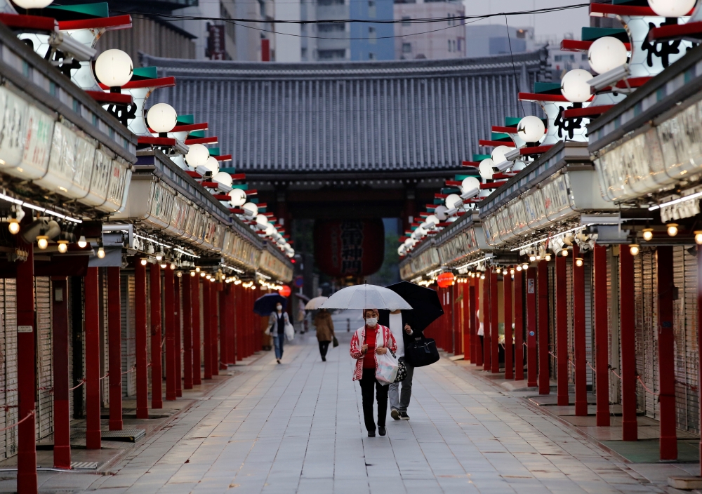 People wearing protective face masks, amid the coronavirus disease (COVID-19) pandemic, walk past closed shops in Asakusa district in Tokyo, Japan, May 7, 2021. REUTERS/Kim Kyung-Hoon