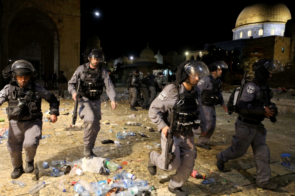 Israeli police run during clashes with Palestinians at the compound that houses Al-Aqsa Mosque in Jerusalem's Old City on May 7, 2021. (Reuters/Ammar Awad)