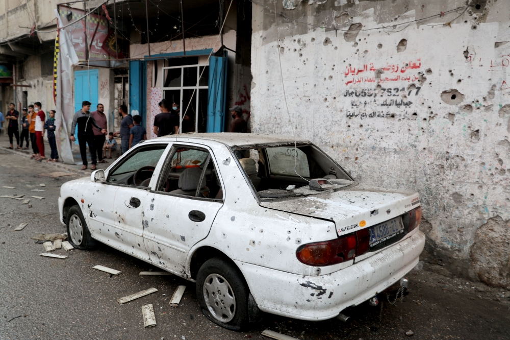 A damaged car is seen at the site where Palestinians were killed in the northern Gaza Strip on May 10, 2021. (REUTERS)