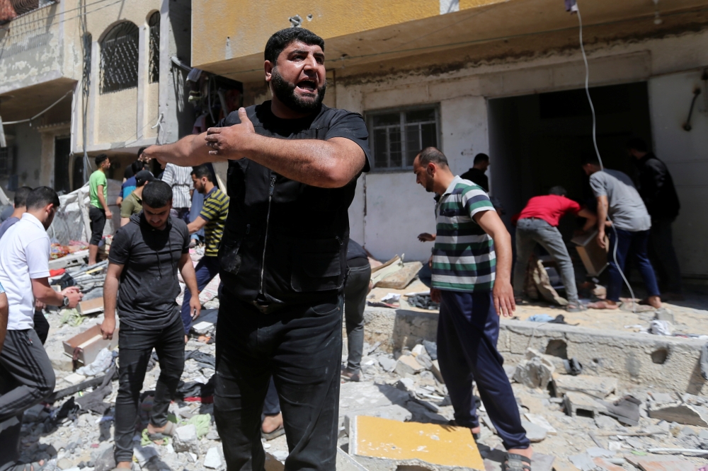 A Palestinian man reacts at the scene where a house was hit by an Israeli air strike, amid a flare-up of Israeli-Palestinian violence, in the southern Gaza Strip May 12, 2021. REUTERS/Ibraheem Abu Mustafa