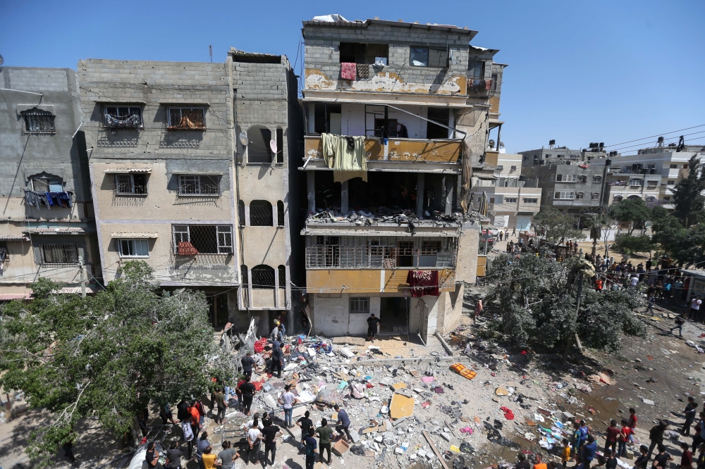 Palestinians gather around a house after it was hit by an Israeli air strike, amid a flare-up of Israeli-Palestinian violence, in the southern Gaza Strip May 12, 2021. REUTERS/Ibraheem Abu Mustafa