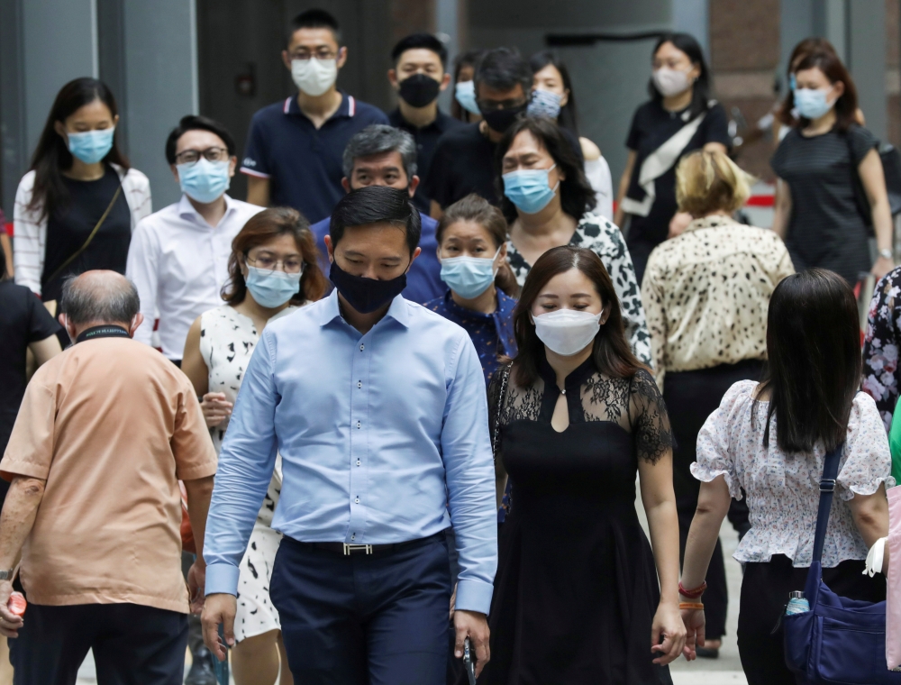Office workers wearing masks cross a street during lunch hour, amid the coronavirus disease (COVID-19) outbreak, in Singapore May 12, 2021. REUTERS/Dawn Chua/File Photo