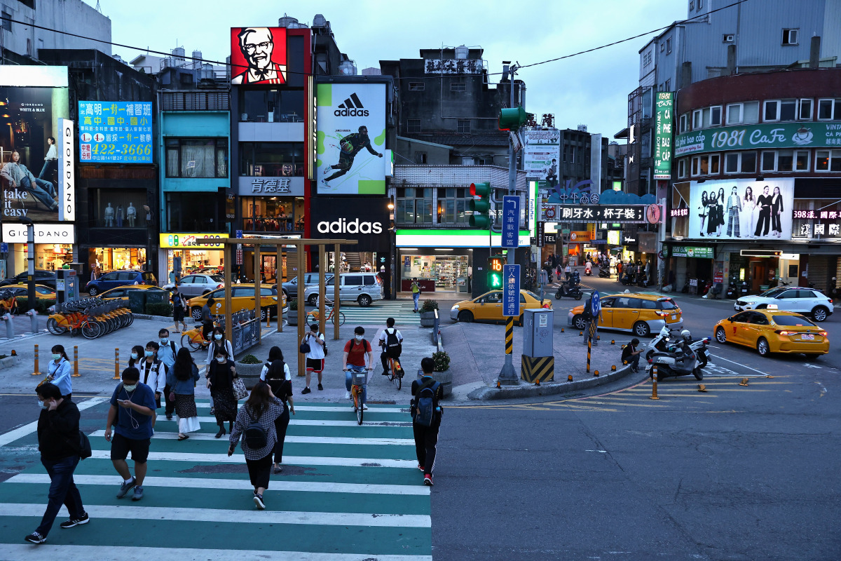 People wear protective face masks while crossing the street amid the coronavirus disease (COVID-19) pandemic, in Taoyuan, Taiwan, May 12, 2021. REUTERS/Ann Wang
