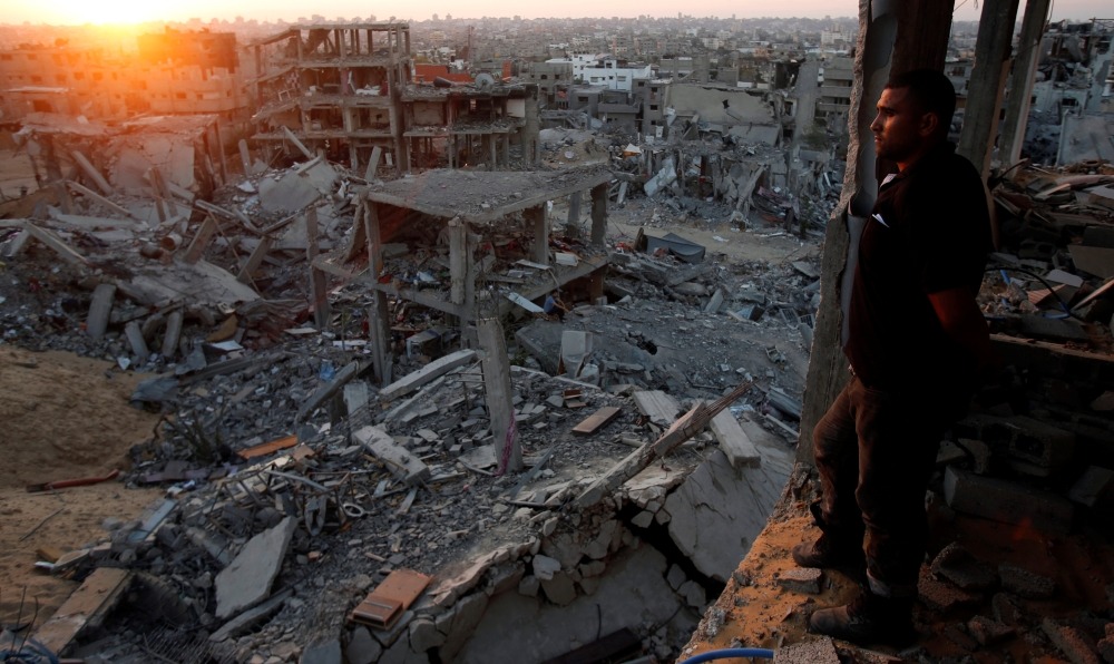 FILE PHOTO: A Palestinian man looks out of his heavily damaged house at neighbouring houses which witnesses said were destroyed during the Israeli offensive, in the east of Gaza City September 3, 2014. REUTERS/Suhaib Salem/File Photo
