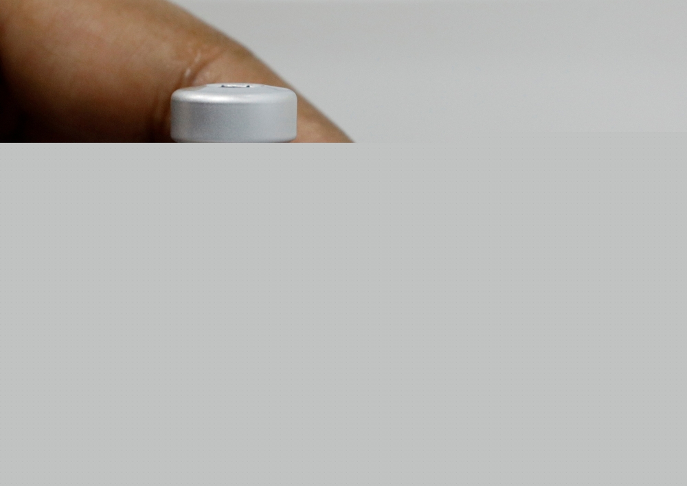 A medical worker prepares to dilute a vial of Pfizer-BioNTech vaccine at a coronavirus disease (COVID-19) vaccination center in Singapore March 8, 2021. REUTERS/Edgar Su/File Photo