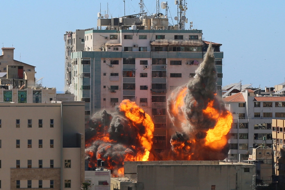 The al-Jalaa building housing Associated Press (AP) and Al Jazeera media offices is hit by an Israeli air strike in Gaza City, May 15, 2021. REUTERS/Ashraf Abu Amrah
