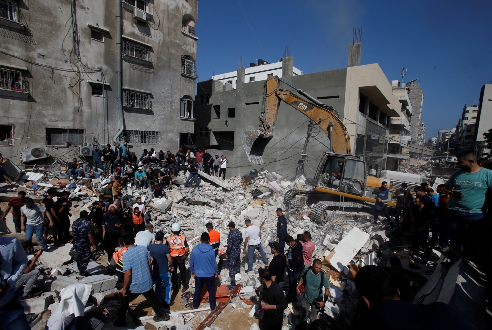 Rescue workers search for victims amid rubble at the site of Israeli air strikes, in Gaza City May 16, 2021. (REUTERS/Mohammed Salem)