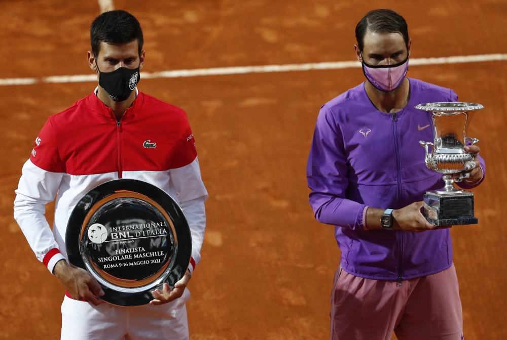 Spain's Rafael Nadal with the trophy after winning his final match against Serbia's Novak Djokovic who poses with the runners up trophy REUTERS/Guglielmo Mangiapane