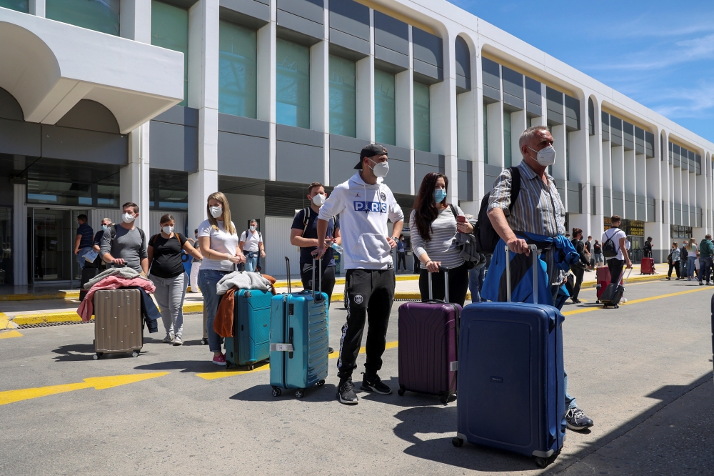 Passengers arriving from Germany and Switzerland line up outside the terminal of the Heraklion airport, as the country's tourism season officially opens, on the island of Crete, Greece, May 15, 2021. Reuters/Stefanos Rapanis